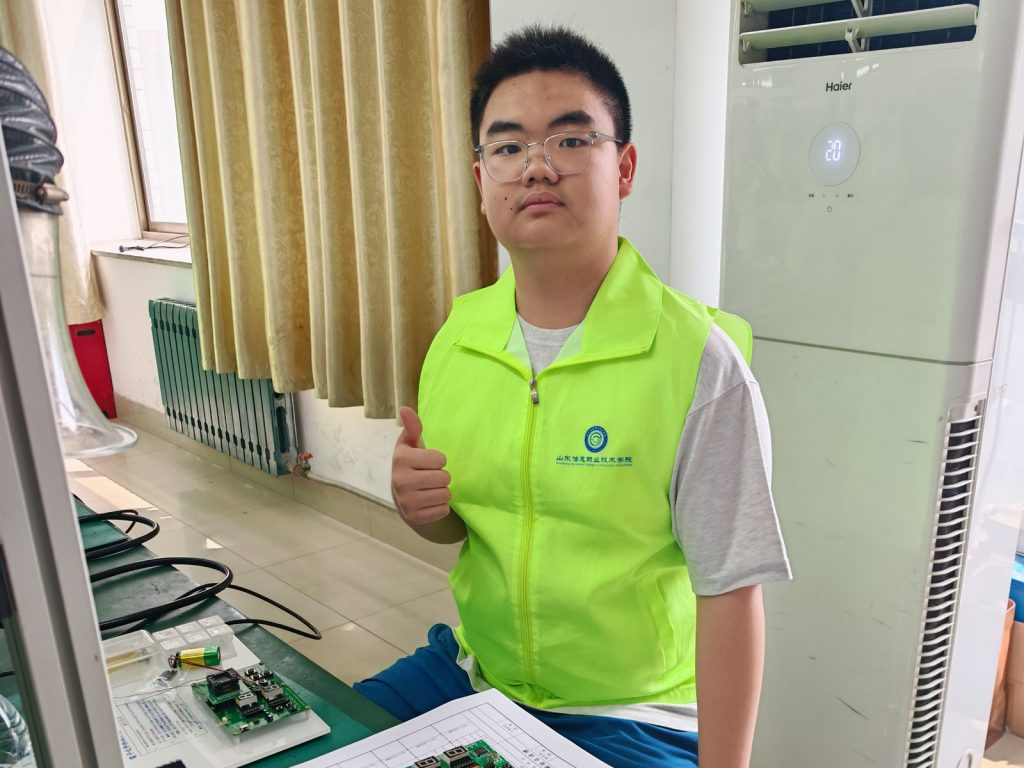 袁沛平在電子組件拆焊專業級實操比賽工作台前。